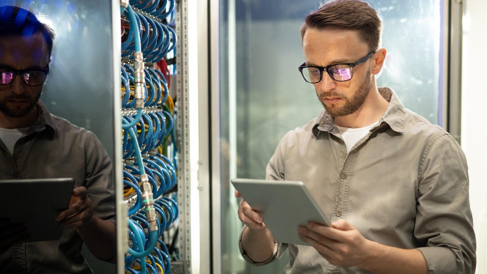 Database administrator looking at his iPad and assessing servers.